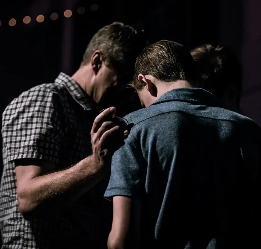 man praying for younger man
