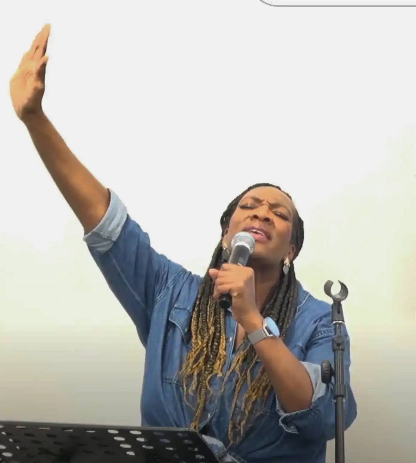 Woman with hand up whilst singing